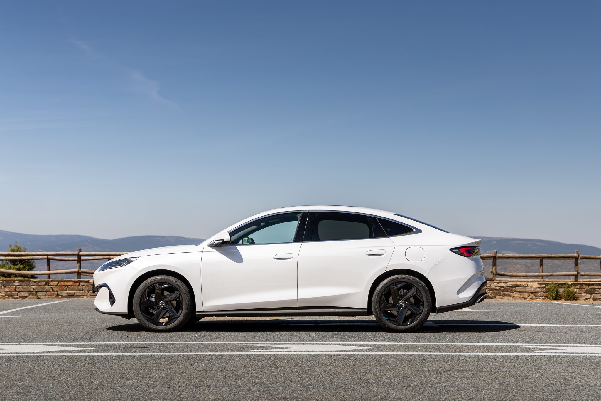 Vista lateral del BYD Seal Touring circulando en carretera, con diseño moderno y enfoque en tecnología híbrida y autonomía extendida