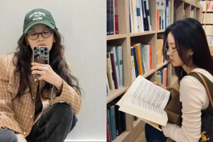 Mujer joven sonriendo con calma, disfrutando de un momento para sí misma, en un café iluminado por luz natural.