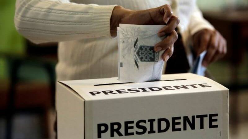 Ciudadana costarricense deposita su voto en una urna electoral durante las elecciones nacionales