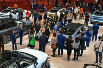 Autos eléctricos en un concesionario en China con clientes observando diferentes modelos en exhibición