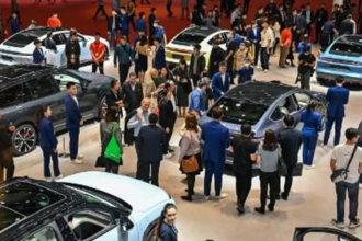 Autos eléctricos en un concesionario en China con clientes observando diferentes modelos en exhibición