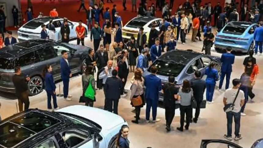 Autos eléctricos en un concesionario en China con clientes observando diferentes modelos en exhibición